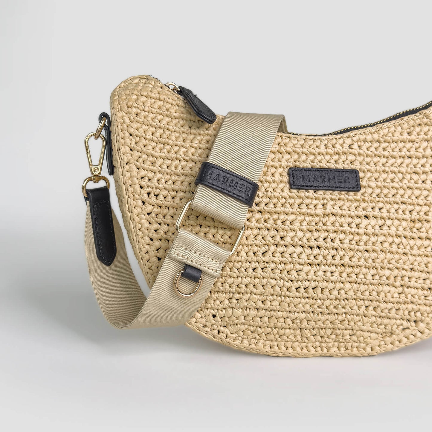 Beige woven handbag with a strap on a light gray background