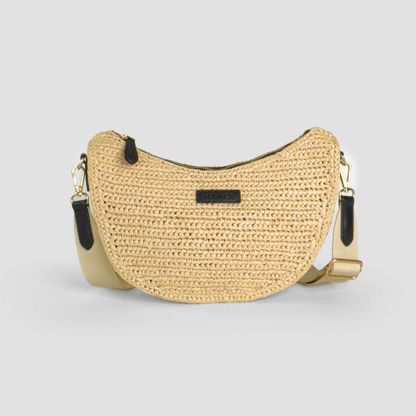 Woven handbag with gold accents on a light gray background