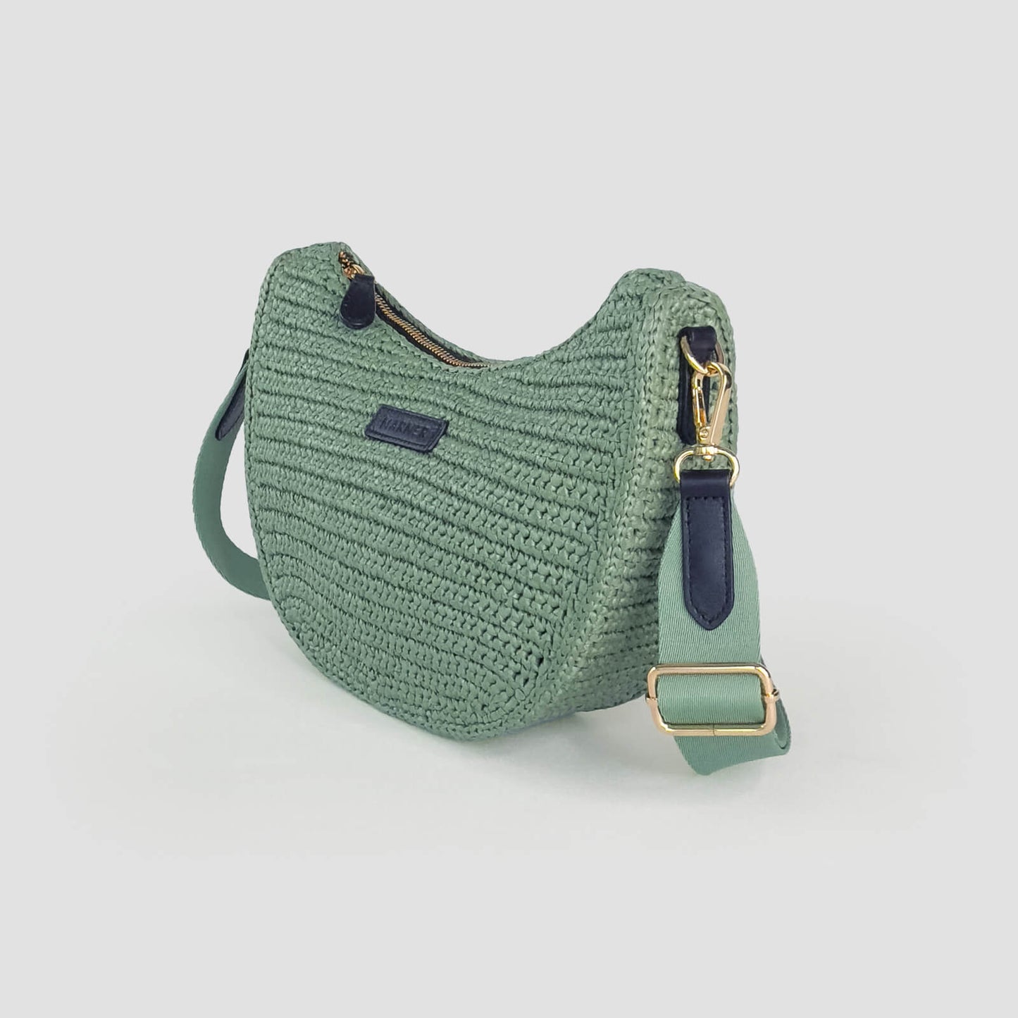 Green crochet bag with gold buckle on a light gray background