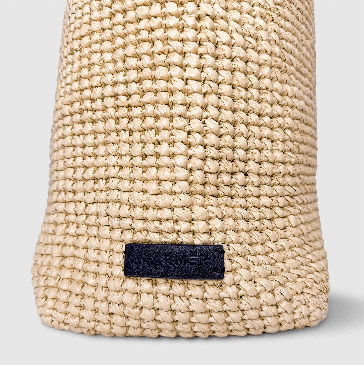 Side angle with Marmer logo of handmade tote bag on neutral background.