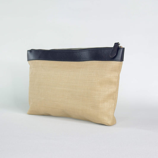 Beige pouch with black leather trim and black zipper on a white background