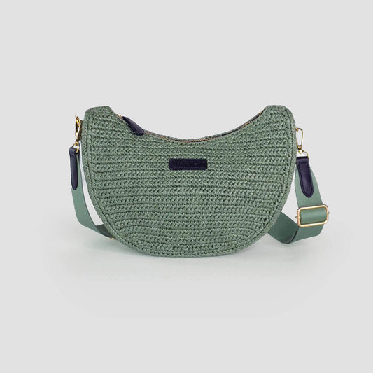 Green woven handbag with a strap on a light gray background